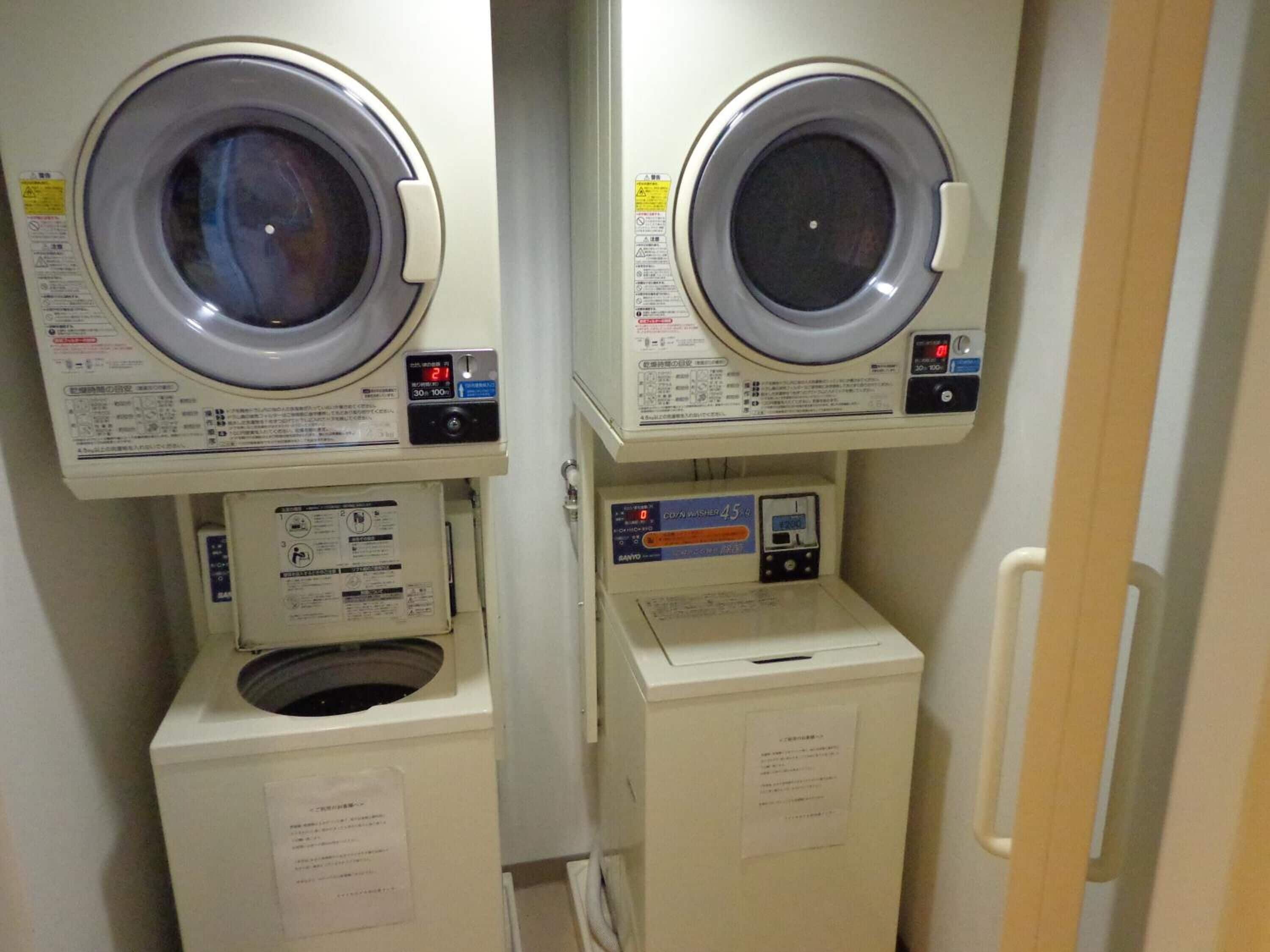 Deux machines à laver superposées dans une buanderie.