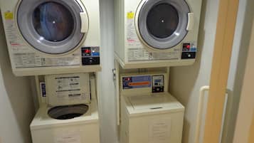 Deux machines à laver superposées dans une buanderie.