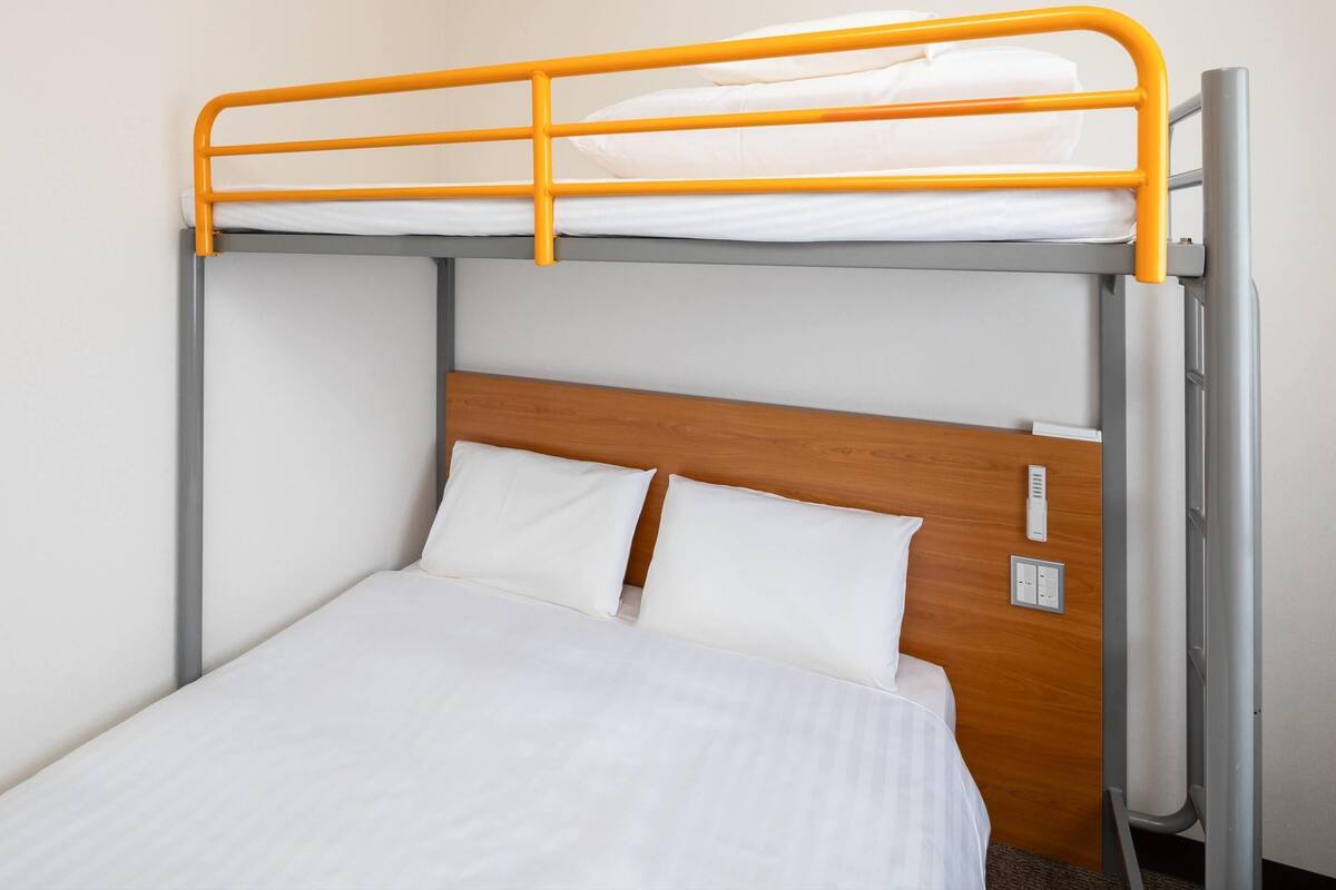 A bunk bed with a wooden headboard and two pillows.