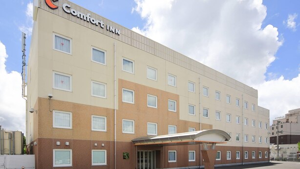 Ein Comfort Inn Hotel mit modernem Design, das eine glatte Fassade, viele Fenster und einen überdachten Eingang zeigt.