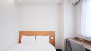 Ein Hotelzimmer mit Bett, Schreibtisch und Stuhl.