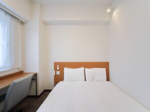 Cubrecamas, escritorio y espacio para trabajar con laptop 