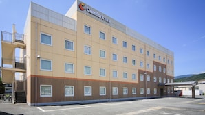 Um hotel com vários andares e fachada plana, com o logo Comfort Inn em destaque e um estacionamento na frente.