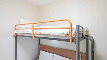 A bunk bed with a wooden headboard and a lower single bed.