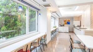 Een moderne keuken met witte kasten, een aanrecht en uitzicht op groen.