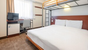 Een hotelkamer met een stapelbed, een bureau met een televisie, een stoel en een kleine koelkast.