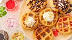 Ein Teller Waffeln mit verschiedenen Belägen und Sirupen.