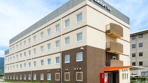 A multi-story hotel with a 'Comfort Inn' sign, a Coca-Cola vending machine, and a parking lot. - Comfort Inn Kofu Isawa (Fuefuki)