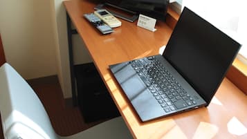 Copriletto in piuma, una scrivania, postazione laptop, tende oscuranti