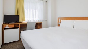 A hotel room with a bed, a desk, a television, and a mini-fridge. - Comfort Inn Kofu Isawa (Fuefuki)