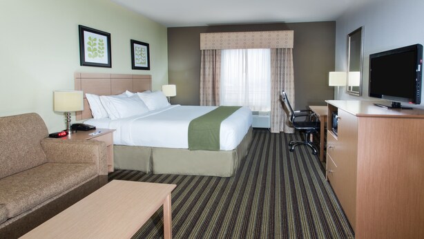 Ein Hotelzimmer mit Bett, Schreibtisch, Fernseher, Sofa und Couchtisch.