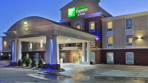 A Holiday Inn Express & Suites building with a covered entrance, a parking lot, and a landscaped area with a fountain. - Holiday Inn Express Hotel & Suites Alvarado by IHG (Alvarado)