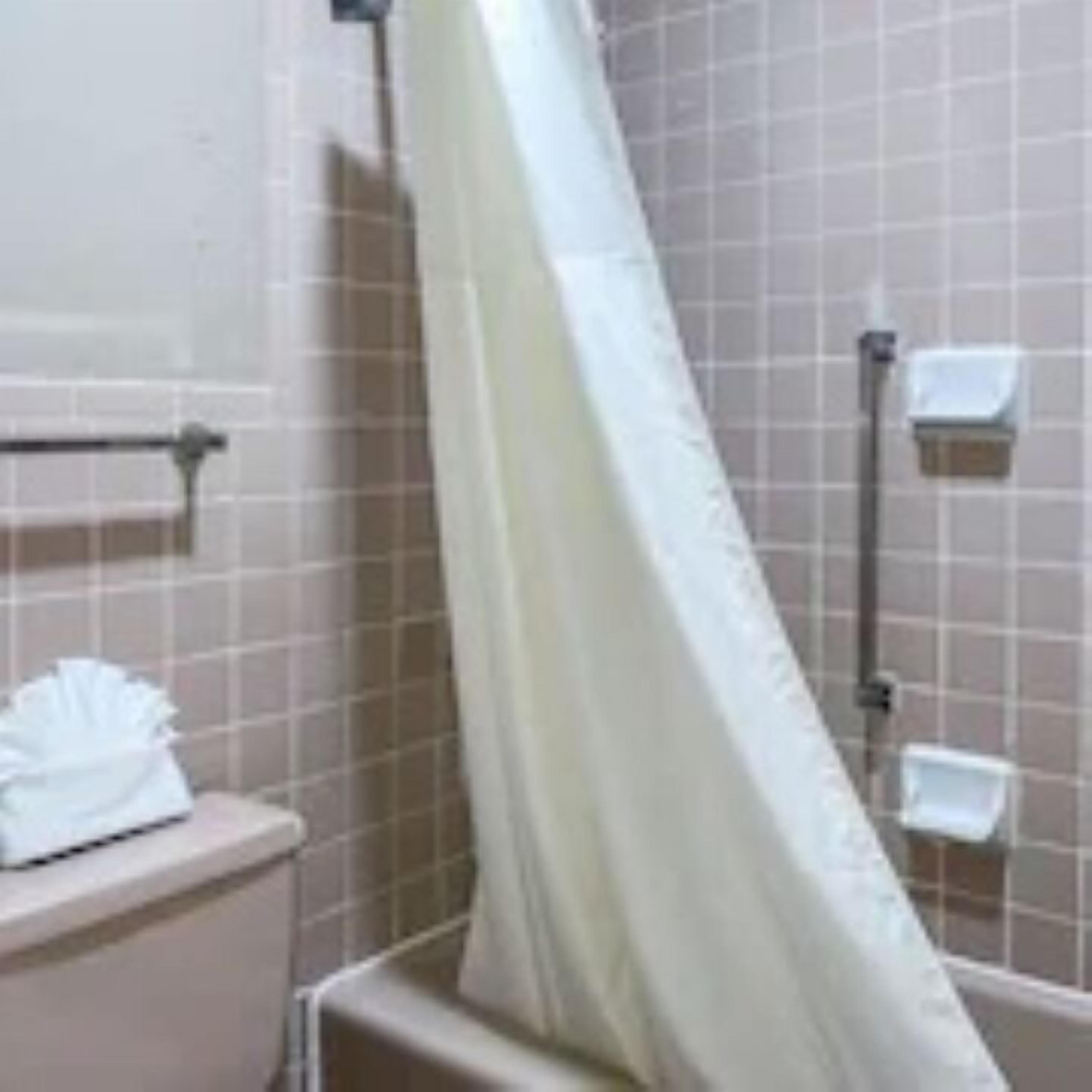 A bathroom with a shower curtain, a towel rack, and a toilet.
