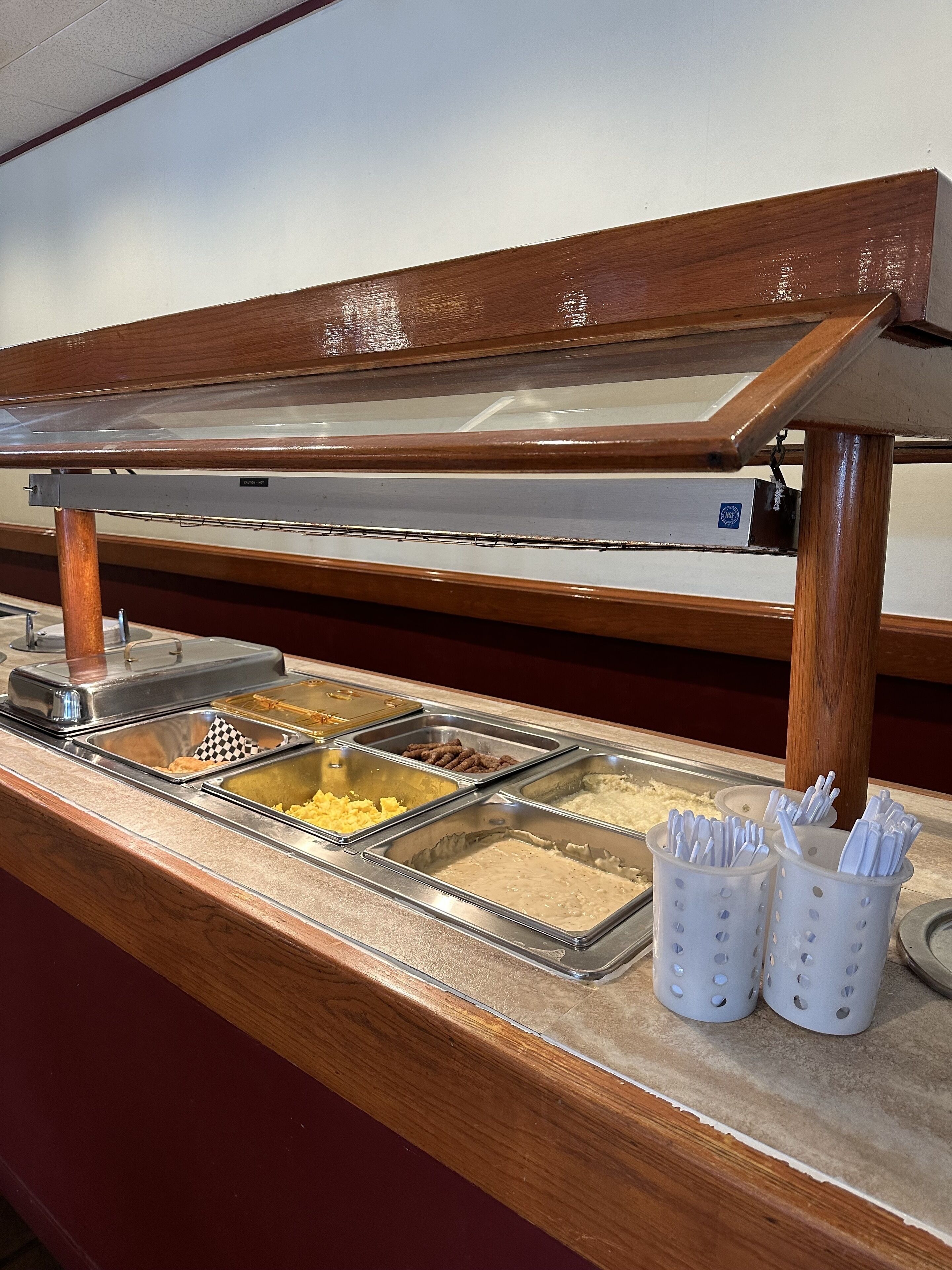 Una mesa de buffet con diversos alimentos y utensilios.