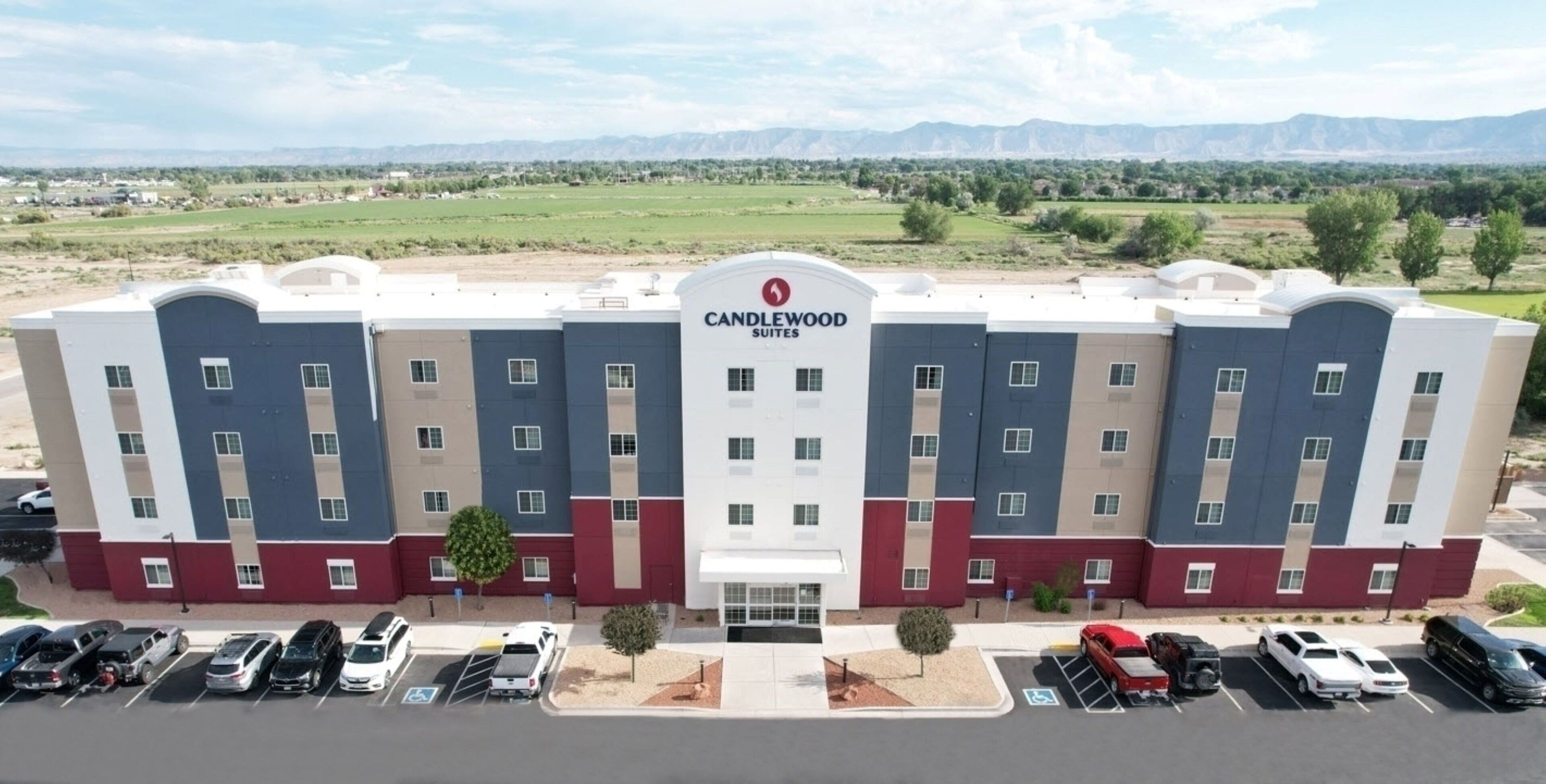 A multi-story hotel with a modern design, featuring a prominent logo at the center.