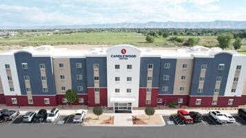 A multi-story hotel with a modern design, featuring a prominent logo at the center.