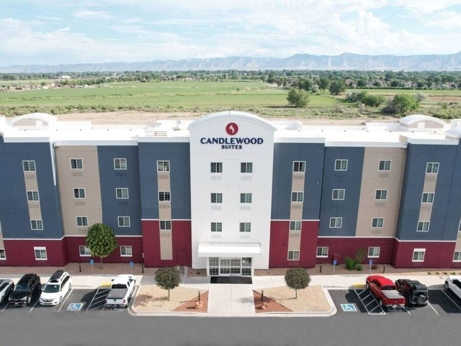 A multi-story hotel with a modern design, featuring a prominent logo at the center.