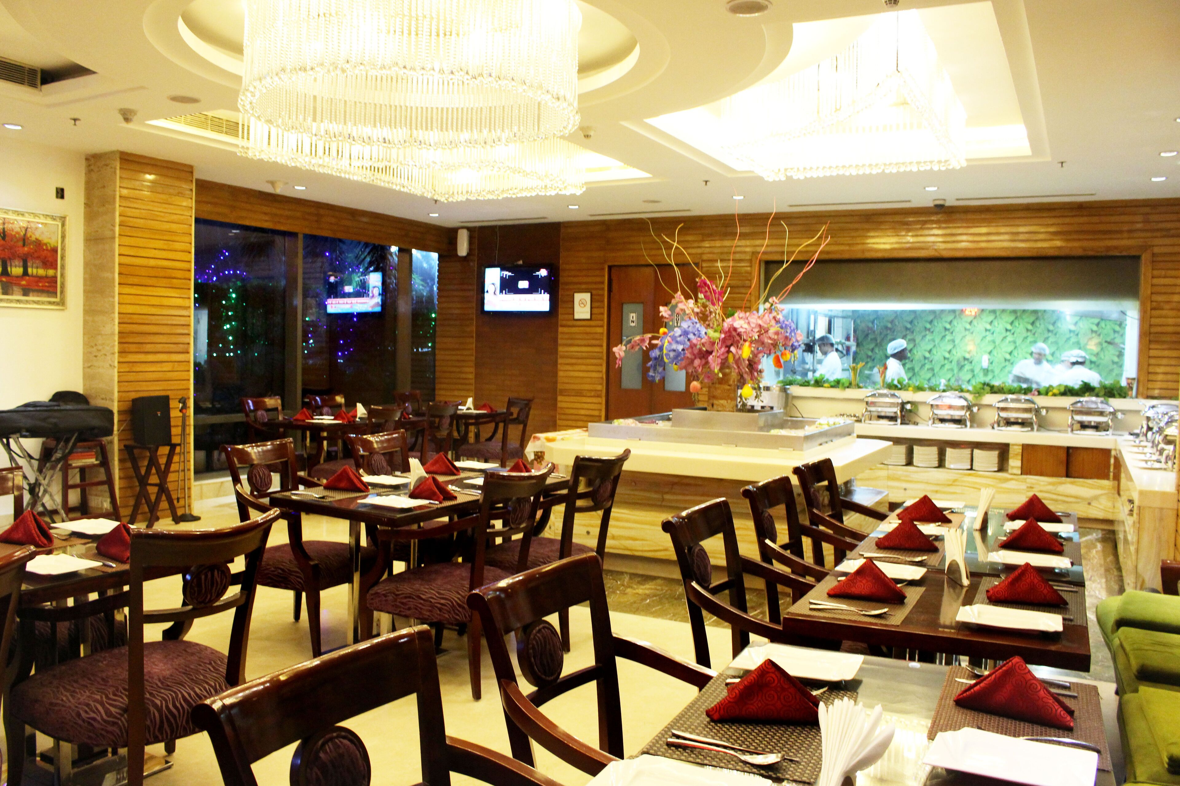 A restaurant with wooden tables and chairs, a large aquarium, and a television screen on the wall.