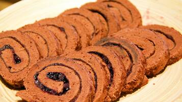 A plate of sliced chocolate rolls with a dark filling.