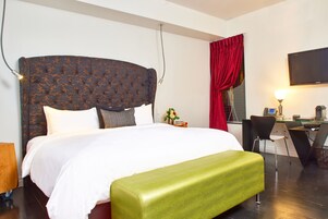 Une chambre d’hôtel avec un grand lit, un bureau et une chaise.