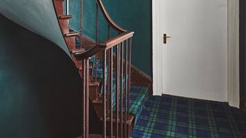 A staircase with a wooden handrail leading to a door marked with the number 6.