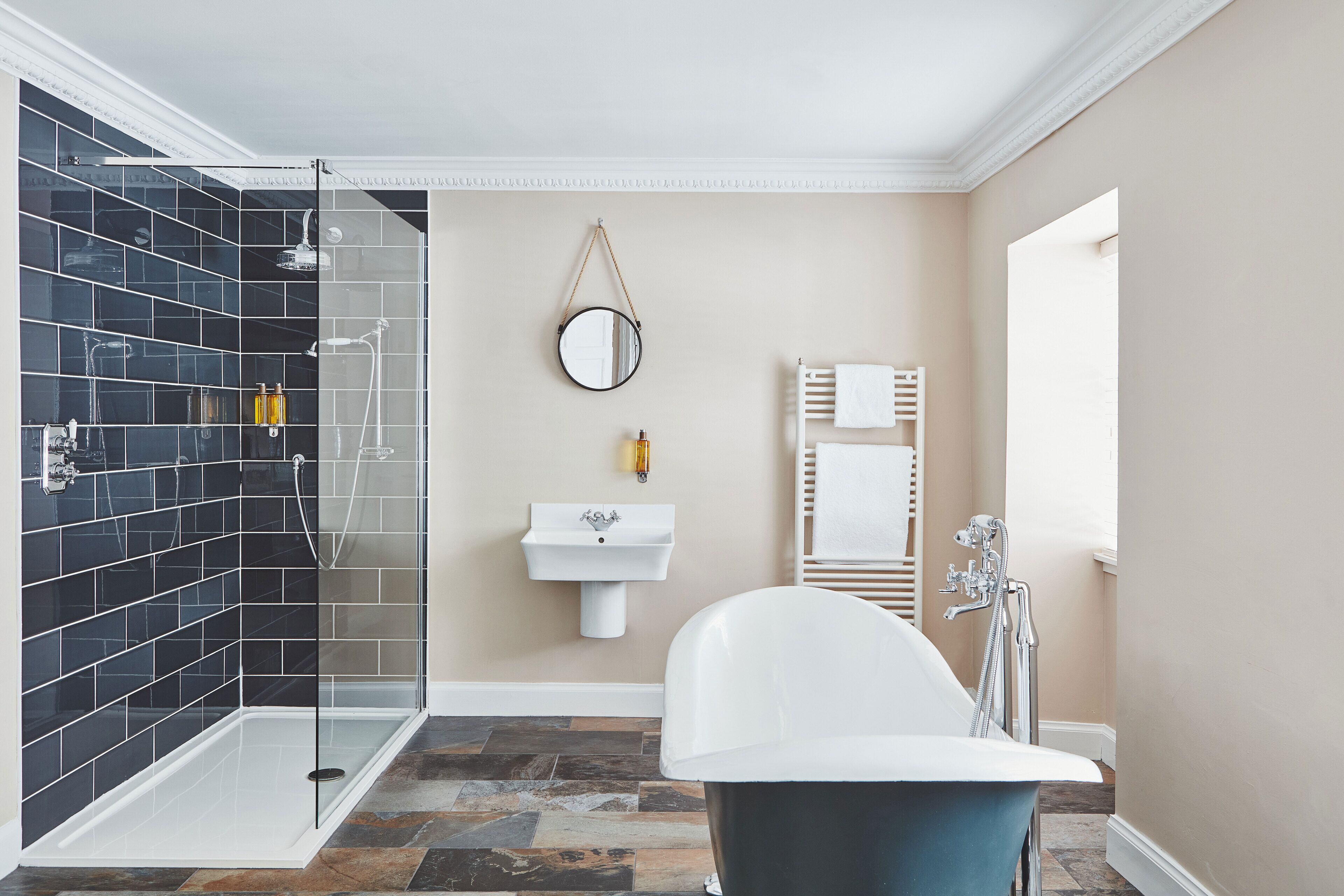A modern bathroom with a glass-enclosed shower, a white sink, and a freestanding bathtub.