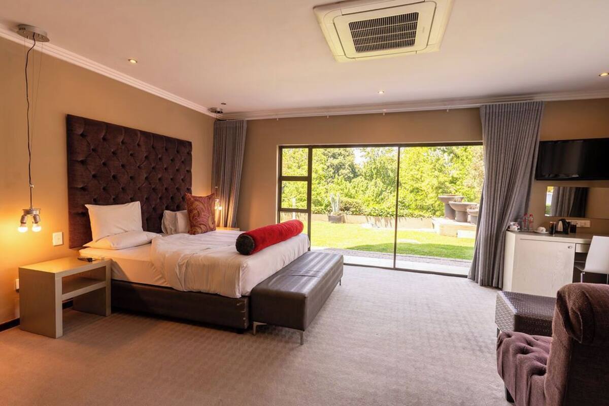 Een moderne hotelkamer met een groot bed, een flatscreen televisie, een bureau en uitzicht op de omgeving.