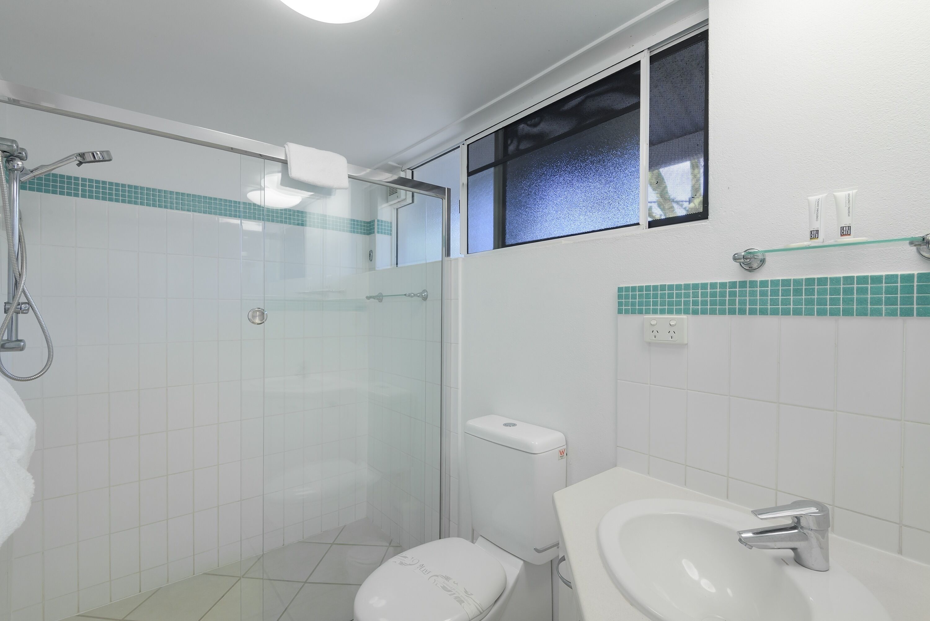 Ein Badezimmer mit Dusche, Toilette und Waschbecken.