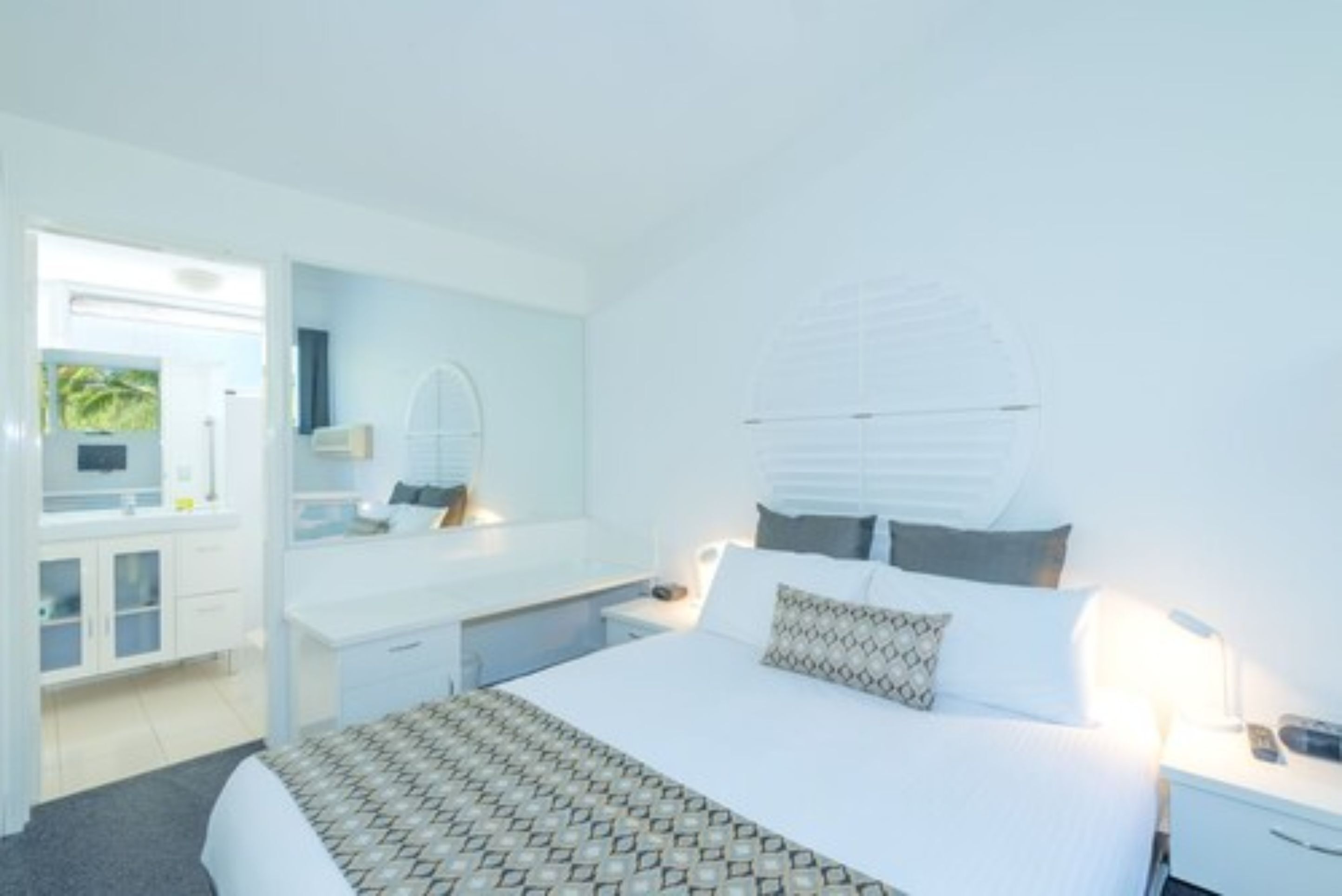 Une chambre d’hôtel moderne avec un grand lit, un bureau et une coiffeuse.