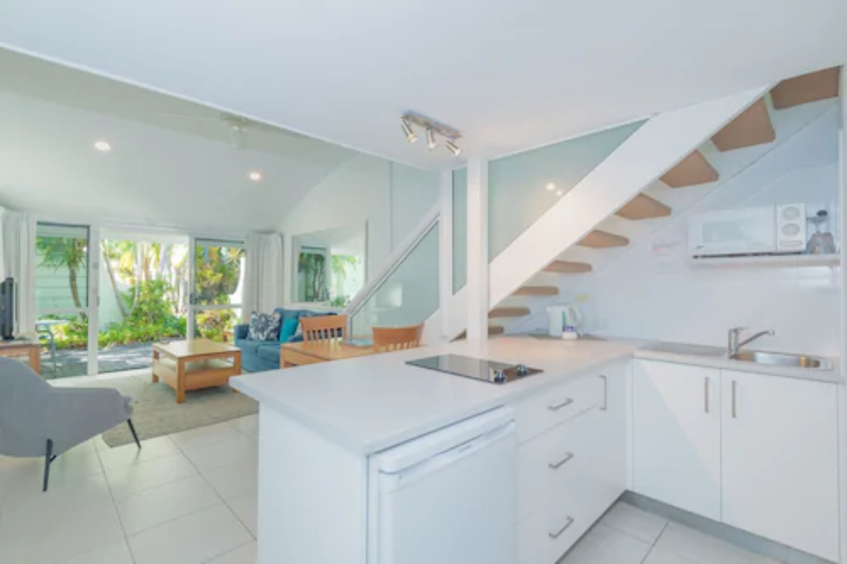 Una cocina moderna con armarios blancos, una estufa integrada y una isla grande.