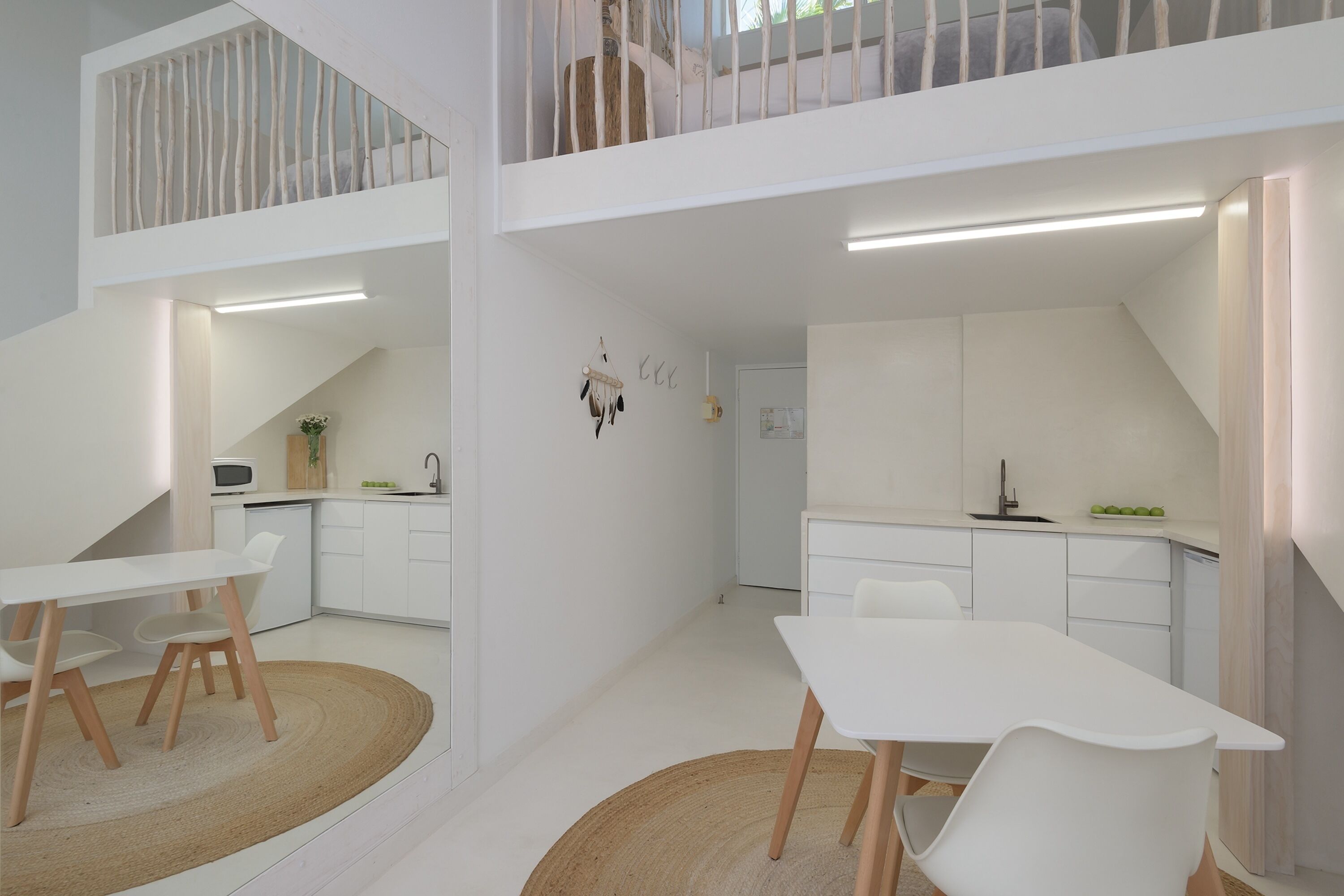 Een moderne, open woonruimte met keuken, eethoek en een slaapverdieping.