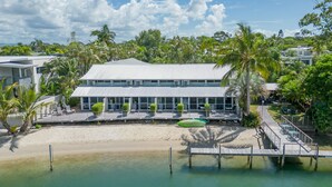 Un resort con playa, palmeras y un muelle.