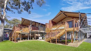 Una casa moderna con varios niveles, escaleras de madera y un espacio exterior cubierto.