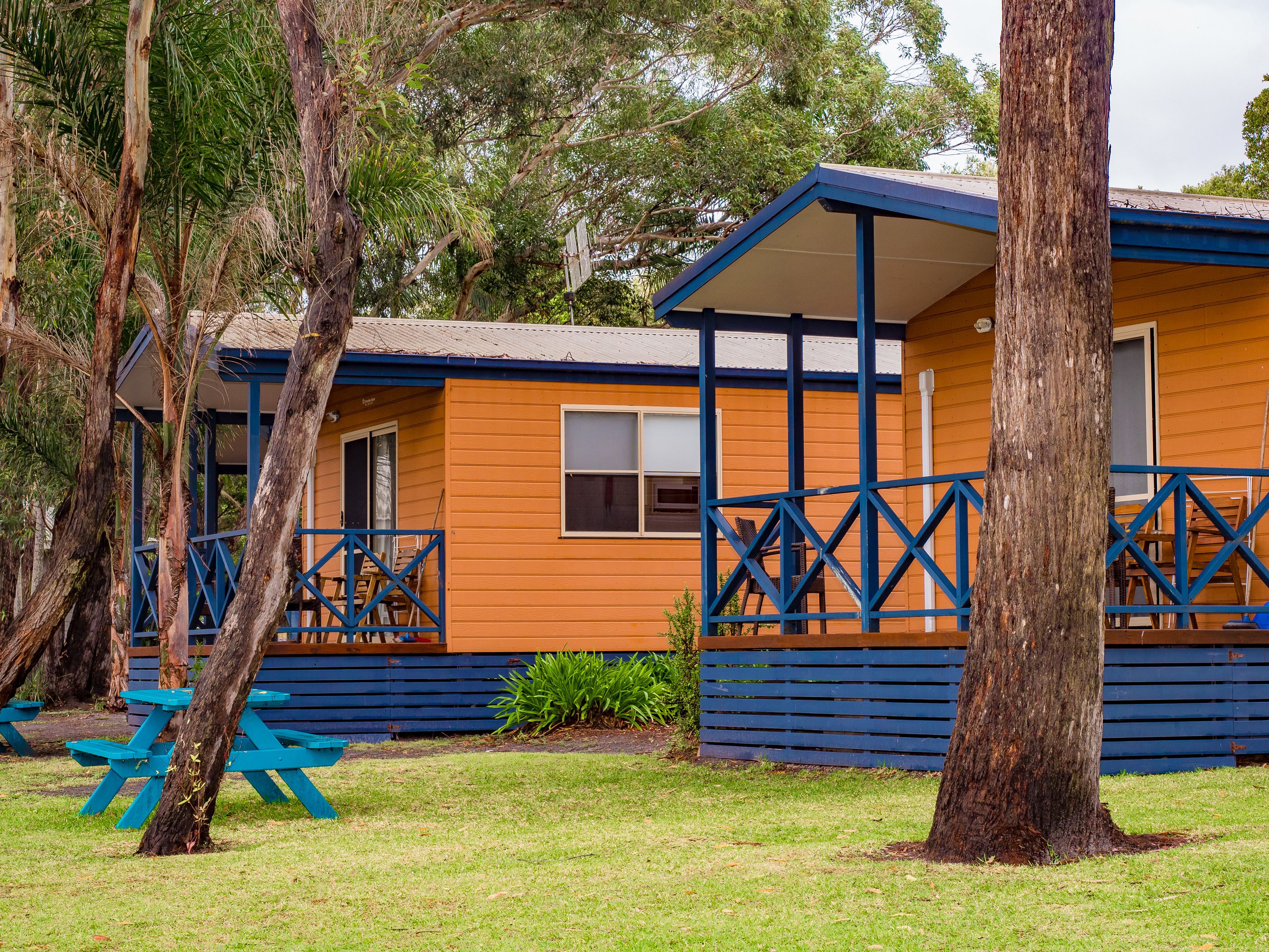 A wooden cabin with a porch and a picnic table.