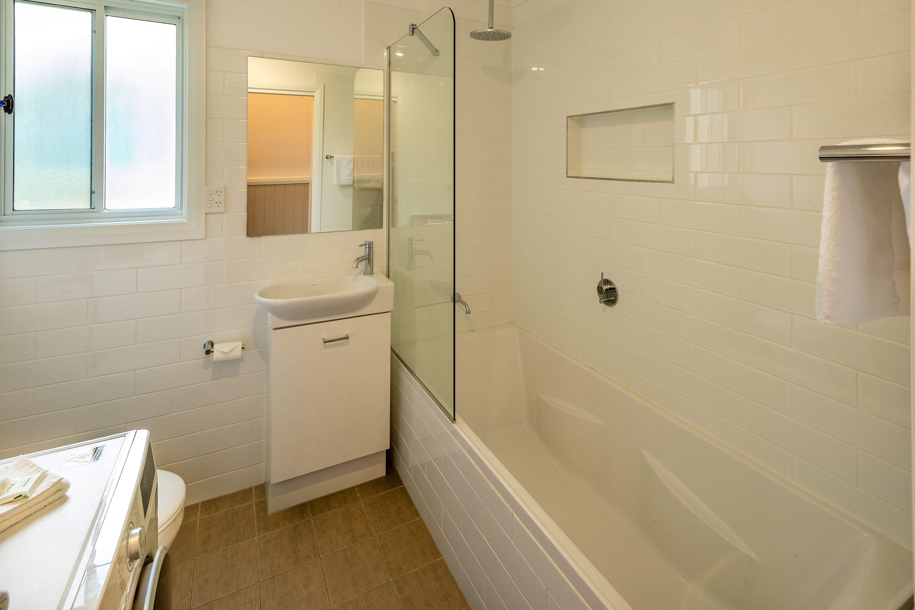 A modern bathroom with a glass-enclosed shower, a sink, and a toilet.