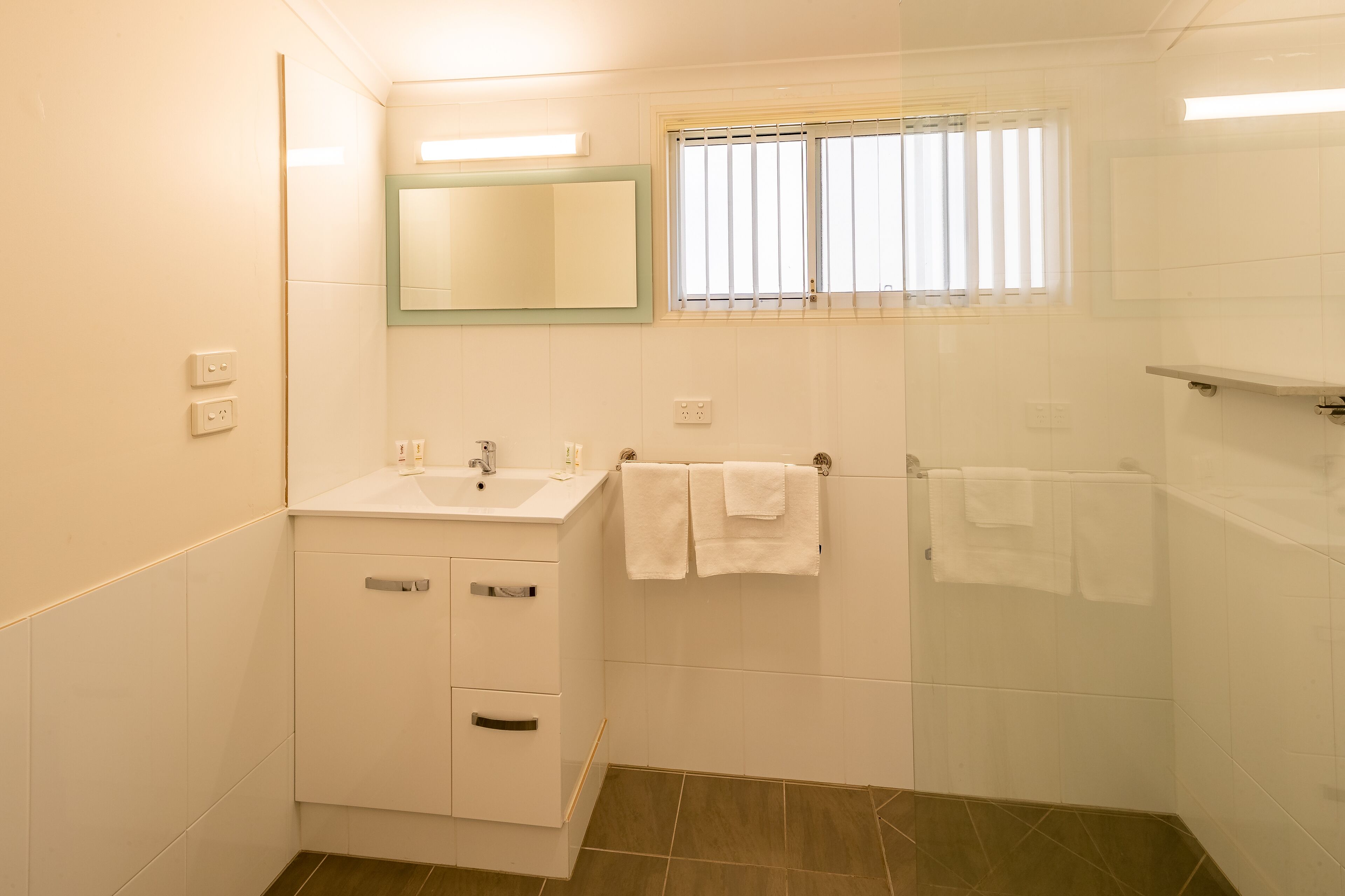 A bathroom with a sink, mirror, and towel rack.