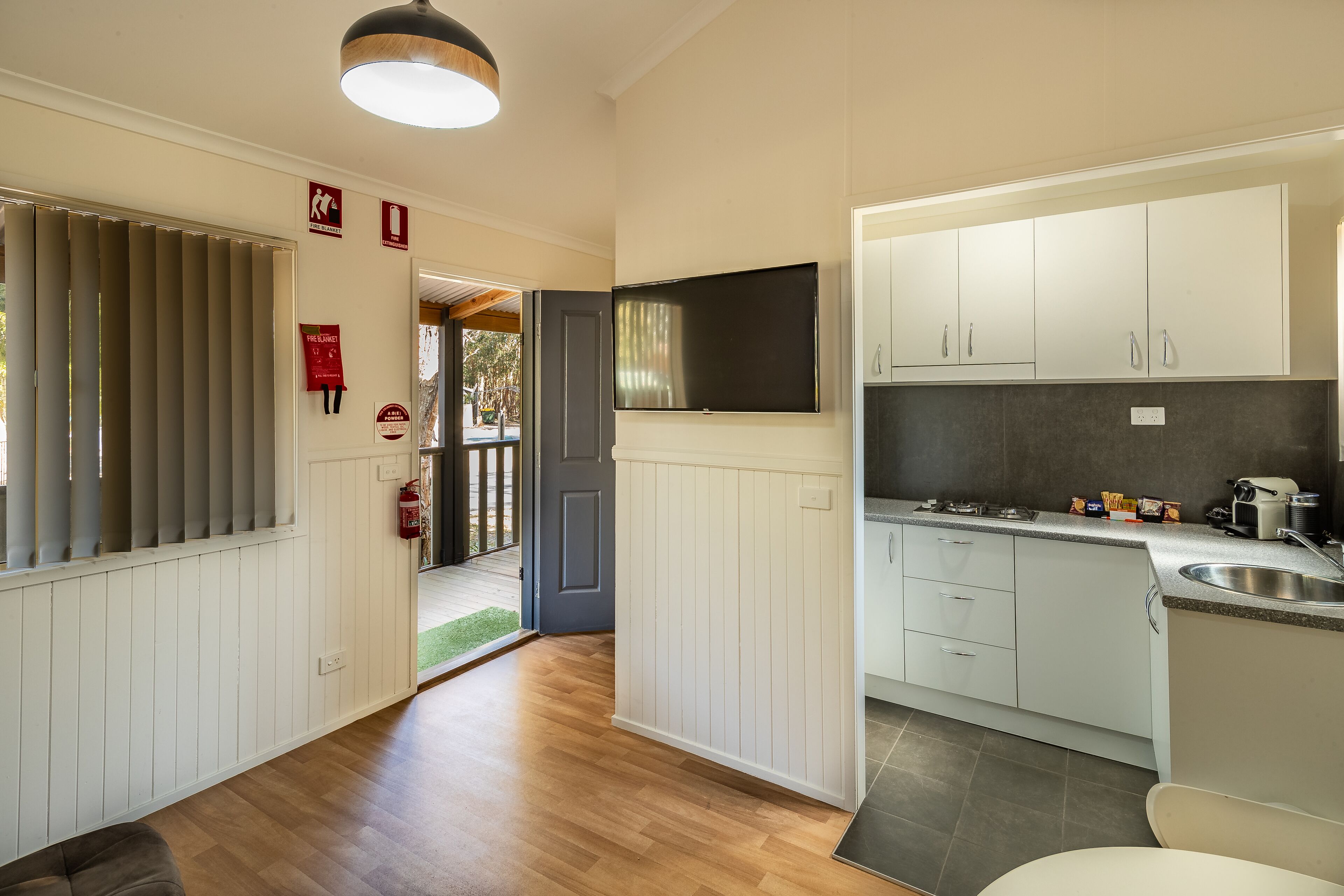 A modern kitchen with white cabinets, a built-in stove, and a large window.