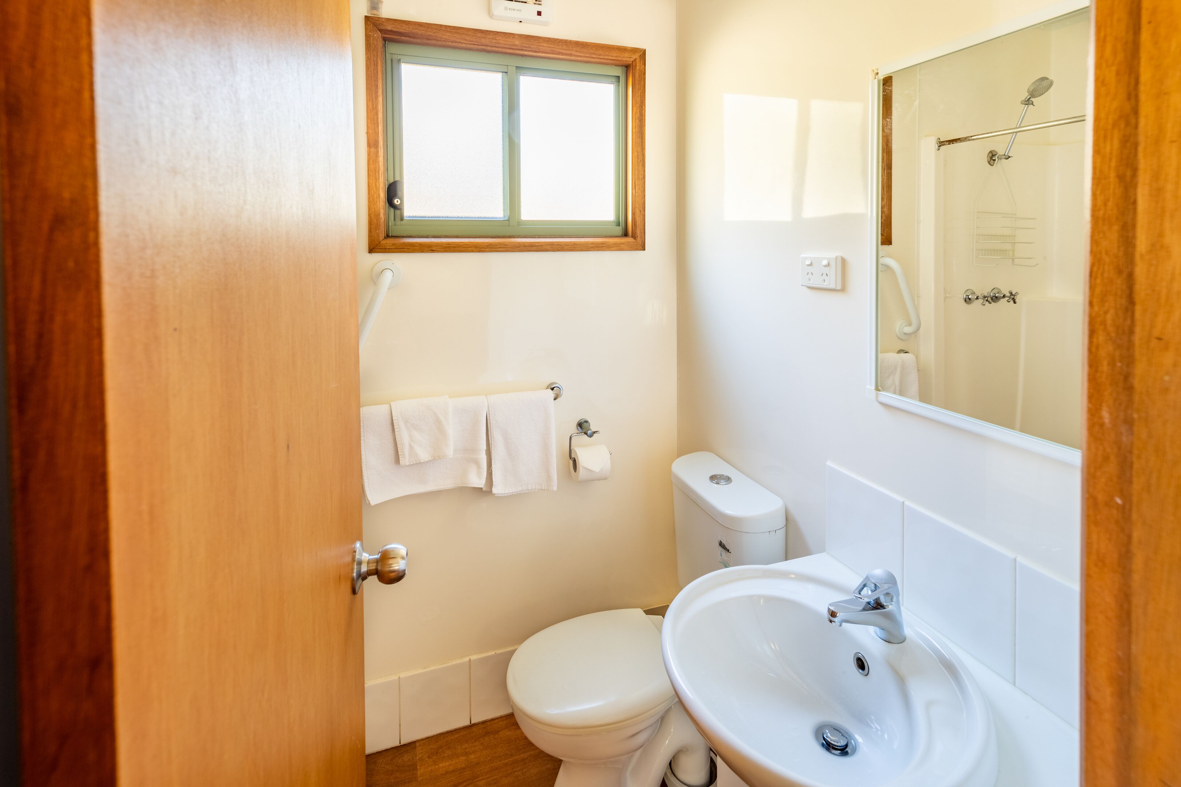 Een badkamer met toilet, wastafel en raam.