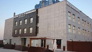A modern building with a sign reading "Restaurante" and "HERMANAS". - Cuatro Hermanas (Sagunto)