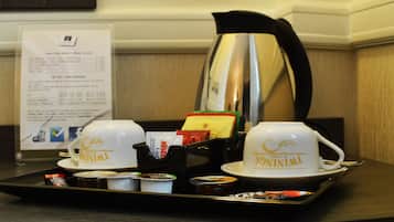 Un vassoio con due tazze etichettate "TWINNIL", una caffettiera e un cartello con il menu in un contesto alberghiero.