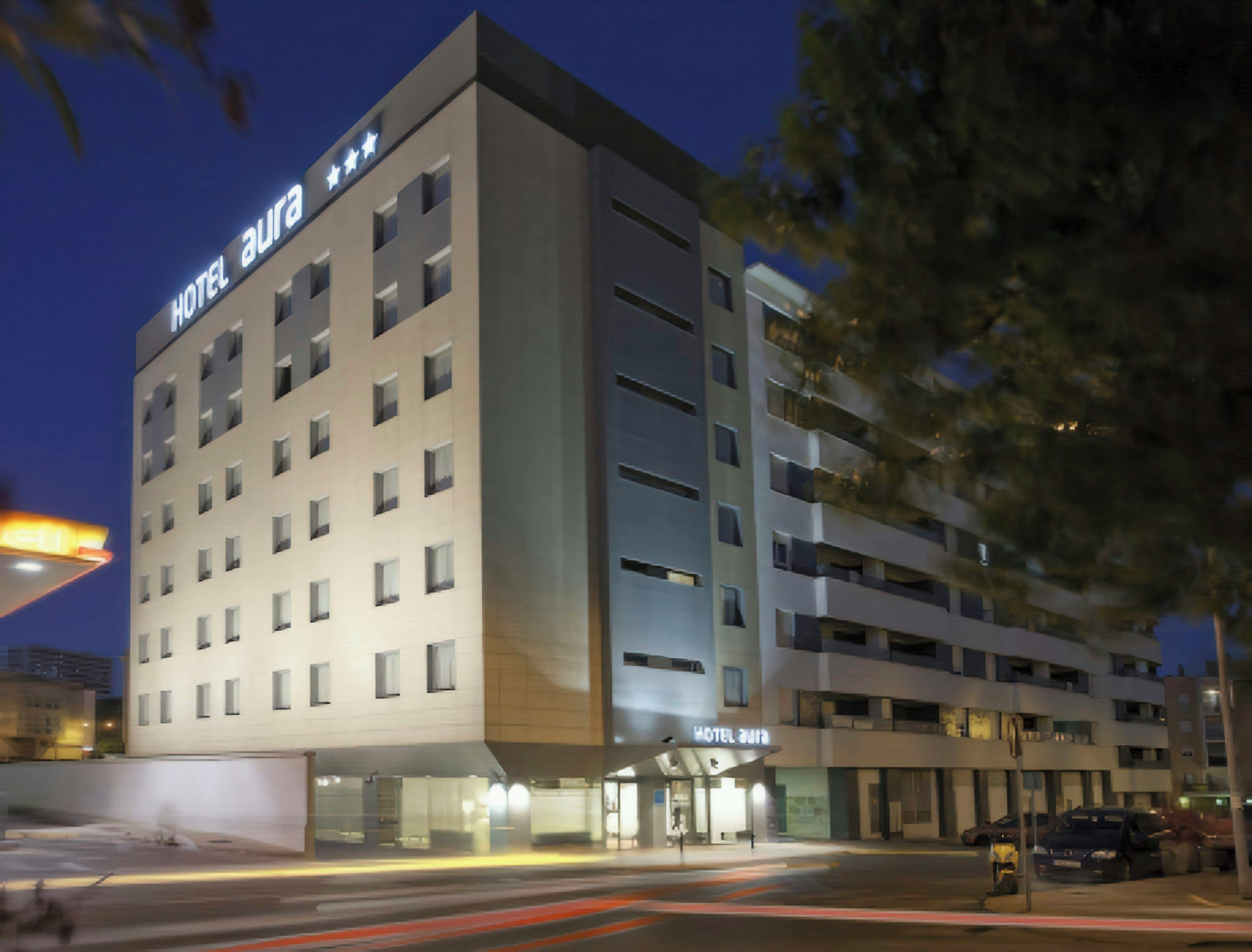A multi-story hotel with a flat facade, multiple windows, and a sign indicating it is a hotel.