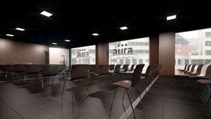 A spacious waiting area with rows of chairs and tables, large windows, and a view of the cityscape. - Sercotel Aura Algeciras (Algeciras)