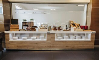 Buffet de café da manhã com diversas opções de comida e um espaço para café.