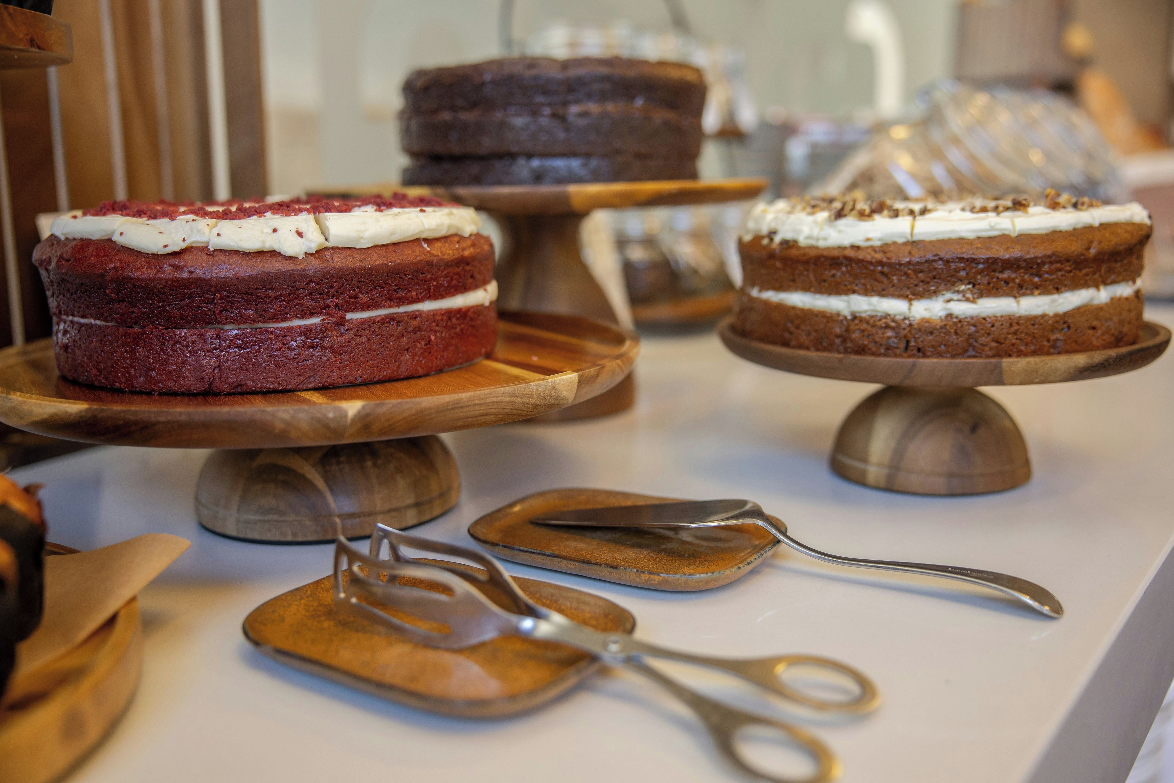 Una exhibición de pasteles sobre pedestales de madera.