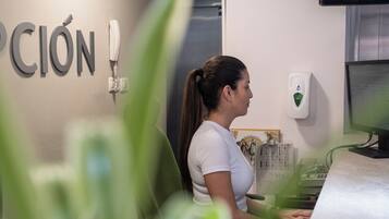 Un área de recepción con un escritorio, una computadora y un teléfono instalado en la pared.