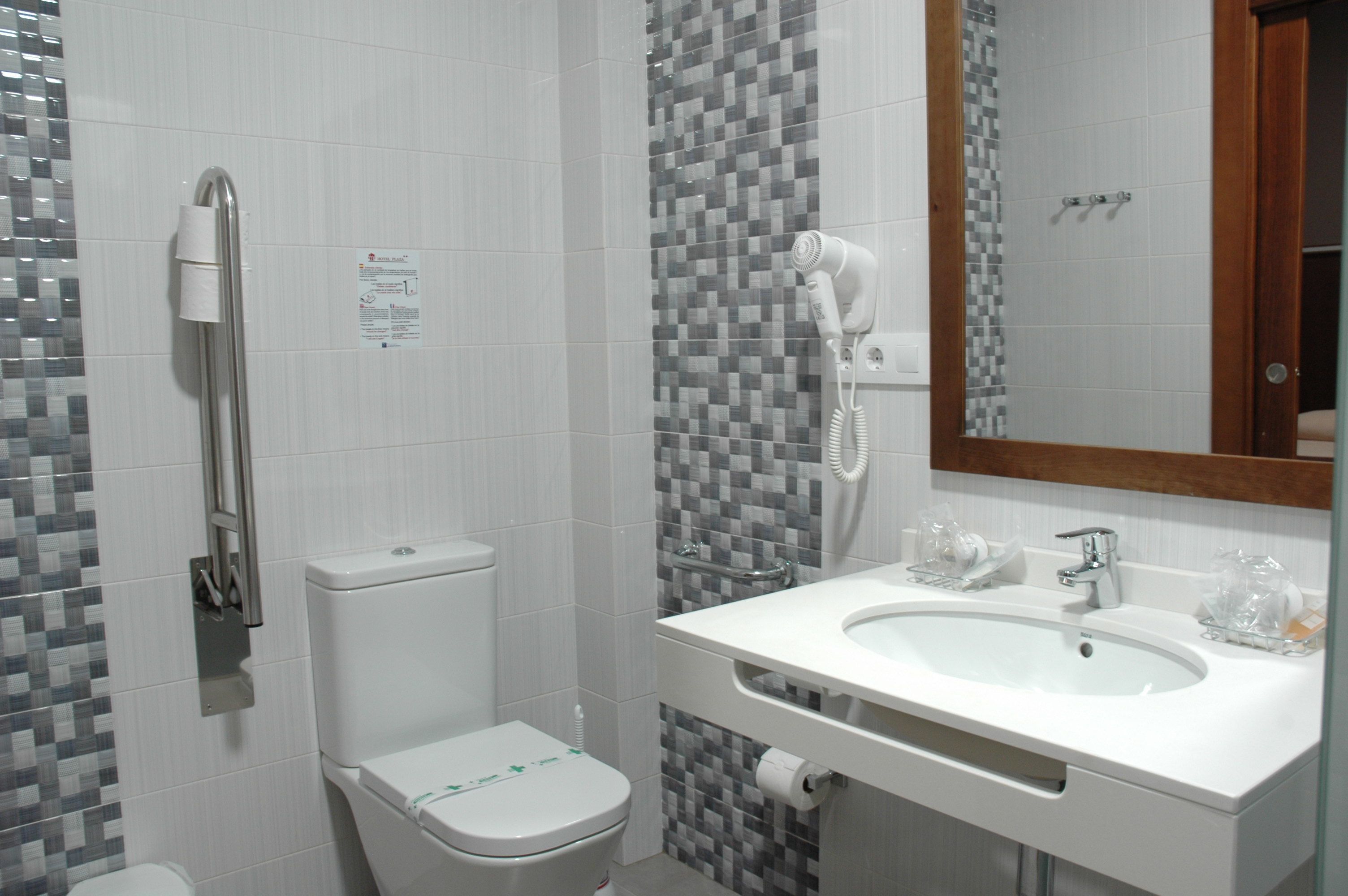 A bathroom with a toilet, a shower, and a sink.