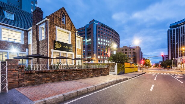 A hotel with a brick facade, a large window, and a sign that reads "mattisse." - Matisse Hotel (Bogotá)