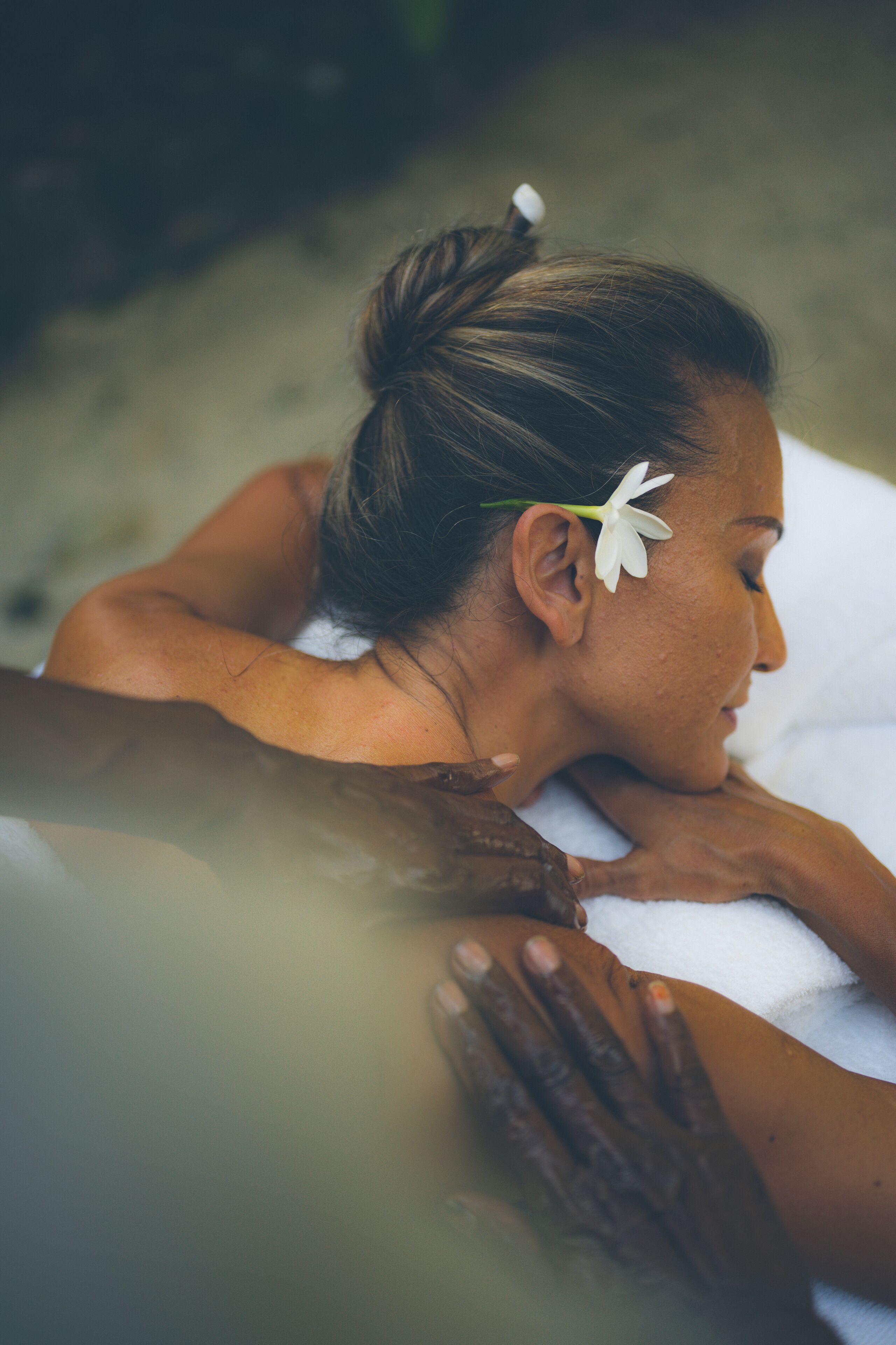 Eine Person erhält eine Massage auf einem weißen Handtuch.