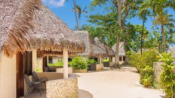 Un complexe hôtelier doté de bungalows aux toits de chaume, d’espaces de détente en plein air et d’une végétation luxuriante.