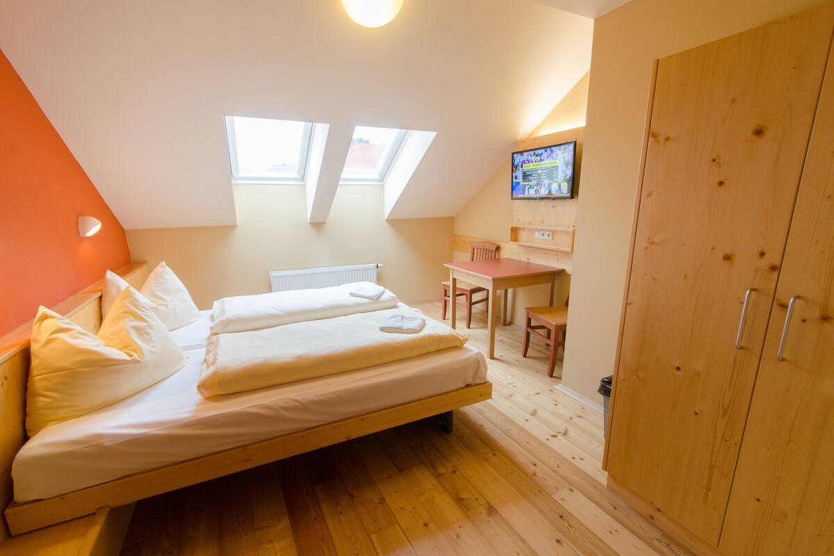 Un dormitorio con cama, escritorio y armario.